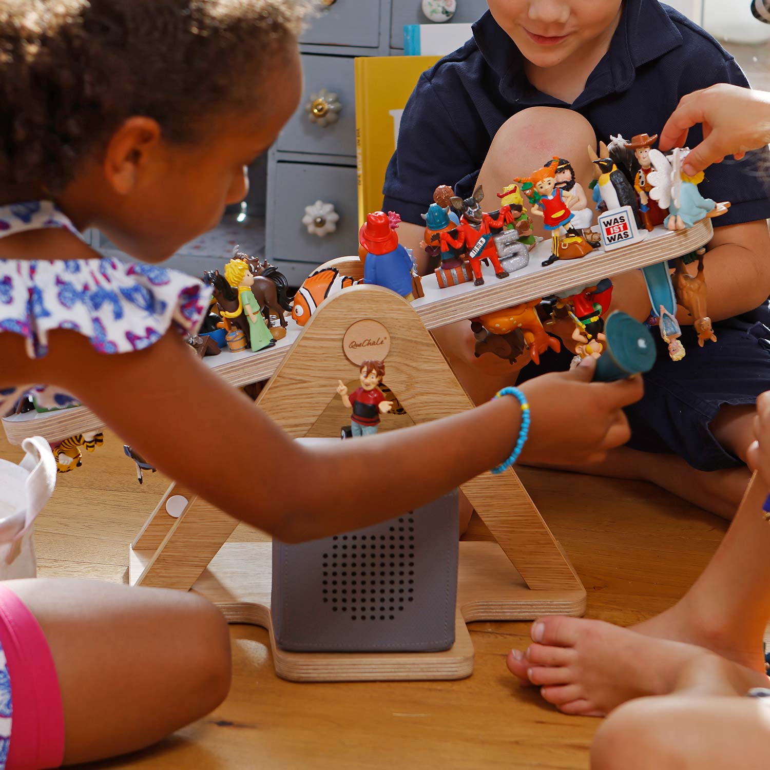 Drei Kinder spielen mit ihren tonies auf der Glück-auf-Waage