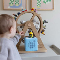 Kleinkind spielt mit einem tonie vor dem Glück-auf-Rad in Woodlove